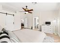 Spacious main bedroom featuring a ceiling fan, barn door, and ensuite bathroom at 68 Belle Soleil Ave, Las Vegas, NV 89123