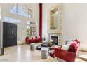 Open foyer featuring tall ceilings, stone fireplace, natural light, and stylish decor at 691 Vineland Ave, Henderson, NV 89052