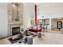 Spacious living room features a soaring ceiling, elegant stone fireplace, and refined dining area at 691 Vineland Ave, Henderson, NV 89052