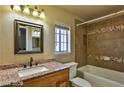Bathroom featuring a granite countertop, a decorative mirror, and a tiled shower at 722 Barrie Ct, Henderson, NV 89002