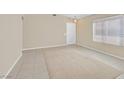 Spacious living room featuring tile flooring, neutral paint, and large window with light-filtering blinds at 7920 Turtle Island Ct, Las Vegas, NV 89129