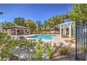 Inviting community pool with lounge chairs and covered seating area, surrounded by mature landscaping at 801 Dana Hills Ct # 101, Las Vegas, NV 89134