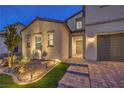 Two-story home showcasing a stucco exterior, a two-car garage, and an inviting entryway with paver walkway at 8984 Rolling Pietra St, Las Vegas, NV 89166