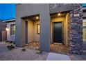 Inviting entryway featuring stone accents, contemporary architecture, and ample lighting for a warm welcome at 909 Allister Fields Ln, Las Vegas, NV 89138