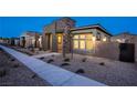 Attractive single-story home featuring neutral color palette, desert landscaping, stone accents, and a sidewalk at 909 Allister Fields Ln, Las Vegas, NV 89138