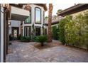 Beautiful courtyard with brick pavers, lush greenery, and large windows offering ample natural light at 9325 Canyon Classic Dr, Las Vegas, NV 89144