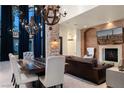 Elegant living room featuring high ceilings, a stone accent wall, and designer light fixtures at 9325 Canyon Classic Dr, Las Vegas, NV 89144