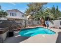 Private backyard pool with a basketball hoop and mature palm trees creates an oasis for relaxation and entertainment at 9449 Amber Valley Ln, Las Vegas, NV 89134