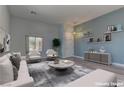 Bright and airy living room featuring stylish furniture, floating shelves, modern décor and a large window at 950 Marbelwood Ave, Las Vegas, NV 89123