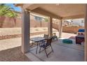 A covered outdoor patio with stone pillars, seating, and minimal desert landscaping at 9746 Vista Cache Ct, Las Vegas, NV 89148