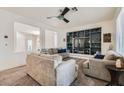 Cozy living room featuring neutral paint, carpet, ceiling fan and custom built-in shelving unit at 10413 Rising Harbor Ave, Las Vegas, NV 89129