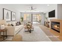 Bright, staged living room features a cozy fireplace, neutral tones, and a sliding glass door to the patio at 121 Staplehurst Ave, Henderson, NV 89002