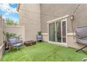 Charming backyard with artificial grass, modern seating and string lights, perfect for outdoor relaxation at 12280 Golden Wreath Rd # 3, Las Vegas, NV 89183