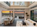 Bright living room with high ceilings, modern decor, and expansive sliding glass doors leading to an outdoor patio at 1491 Reims Dr, Henderson, NV 89012