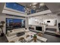 Open-concept living space with a modern fireplace, luxurious seating, and large windows offering panoramic views at 1491 Reims Dr, Henderson, NV 89012