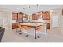 An island kitchen featuring granite countertops, updated stainless steel appliances, and wooden cabinetry at 2194 Trivero St, Henderson, NV 89044