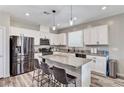 Bright kitchen features white cabinets, stainless steel appliances, and island with barstool seating at 2531 Dollison Ave, North Las Vegas, NV 89081