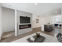Open-concept living area with a fireplace, TV, and kitchen island, perfect for modern living at 2747 Tahiti Grape Way # 2, Las Vegas, NV 89183