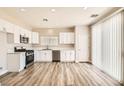 Bright kitchen with stainless steel appliances, white cabinetry, and expansive wood-look flooring at 4118 Beech Family St, Las Vegas, NV 89115
