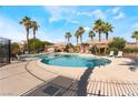 Community pool surrounded by palm trees and lounge chairs for relaxation and enjoyment on sunny days at 4508 Dragon Fly Creek Ave, North Las Vegas, NV 89031