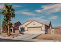 Single-story home with desert landscaping, two-car garage, and well-maintained lawn at 5028 Crying Heart St, North Las Vegas, NV 89031