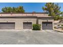 View of multiple garages with brown doors and a landscaped area in front of the garage doors at 5250 S Rainbow Blvd # 2101, Las Vegas, NV 89118