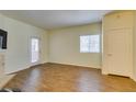 Living room showing hardwood floors, neutral paint, and a glass-paneled door to the outdoor space at 5250 S Rainbow Blvd # 2101, Las Vegas, NV 89118