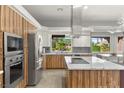 Modern kitchen features sleek stainless steel appliances, a center island, and ample cabinet space at 5680 N Fort Apache Rd, Las Vegas, NV 89149