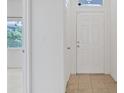 Bright entryway features a white front door, tiled flooring, and a view of the living area with natural light at 6041 Rosanna St, Las Vegas, NV 89113