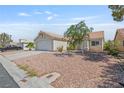 Single-story home with desert landscaping showcasing its two-car garage and easy to maintain front yard at 6209 Lenaking Ave, Las Vegas, NV 89122