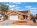 Charming single-story home with a terra cotta roof and solar panels on a sunny day at 6370 Canyon Vista Ct, Las Vegas, NV 89156