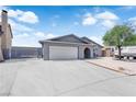 Charming single-story home with a wide driveway, grey paint, and a well-maintained yard at 6741 Bonillo Dr, Las Vegas, NV 89103