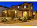Charming two-story home features a three-car garage, stone accents, covered entry and landscaped front yard at 7311 Spring Flower Ave, Las Vegas, NV 89117