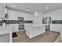Modern kitchen with white cabinets, stainless steel appliances, an island, and stylish backsplash at 7775 Santos Bay Ct, Las Vegas, NV 89179