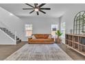Inviting living room with hardwood floors, a ceiling fan, a leather couch, and large windows for natural light at 7775 Santos Bay Ct, Las Vegas, NV 89179