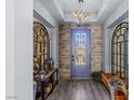Chic foyer features wood-look floors, a modern chandelier, and stylish decor at 8713 Long Winter Ct, Las Vegas, NV 89131