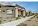 Beautiful front yard with desert landscaping, concrete walkway leading to covered porch with seating area at 912 Allister Fields Ln, Las Vegas, NV 89138