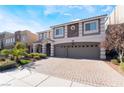 Beautiful home with a three-car garage, brick driveway, and manicured landscaping at 9883 Russian Hill St, Las Vegas, NV 89141