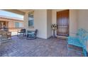 Inviting covered front porch with decorative seating and a well-maintained paver surface at 1000 Via Canale Dr, Henderson, NV 89011
