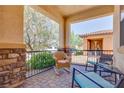 Relaxing covered front porch featuring comfortable seating and a wrought iron railing at 1000 Via Canale Dr, Henderson, NV 89011