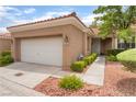 Single-story home showcasing a two-car garage, desert landscaping and a cozy front porch at 10037 Summer Oak Ln # 102, Las Vegas, NV 89134