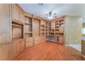 Spacious living room with hardwood floors and a wall of custom built-in cabinets and shelving at 10037 Summer Oak Ln # 102, Las Vegas, NV 89134