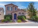 Charming two-story home with desert landscaping, a blue front door, and an attached two car garage at 10454 Gunpowder Falls St, Las Vegas, NV 89183