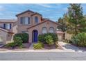Charming two-story home with desert landscaping, a blue front door, and an attached two car garage at 10454 Gunpowder Falls St, Las Vegas, NV 89183