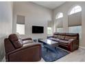 Bright living room with vaulted ceilings, hard surface floors, neutral walls, and comfortable leather furniture at 10454 Gunpowder Falls St, Las Vegas, NV 89183