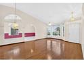 Bright living room featuring hardwood floors, large windows, ceiling fans, and arched doorways at 114 Tamarack Dr, Henderson, NV 89002