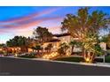 Spacious home with mature landscaping, illuminated steps, and a stucco exterior with a tile roof at dusk at 11906 Port Labelle Dr, Las Vegas, NV 89141