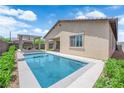 Backyard view with a refreshing pool, a covered patio, and manicured landscaping at 11909 Pippa Ave, Las Vegas, NV 89138