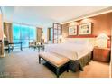 Spacious main bedroom featuring a comfortable bed, seating, and city views at 135 E Harmon Ave # 1703, Las Vegas, NV 89109