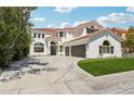 Two-story home with a well-maintained lawn, stucco exterior, tile roof, and multi-car driveway at 2469 Sun Reef Rd, Las Vegas, NV 89128